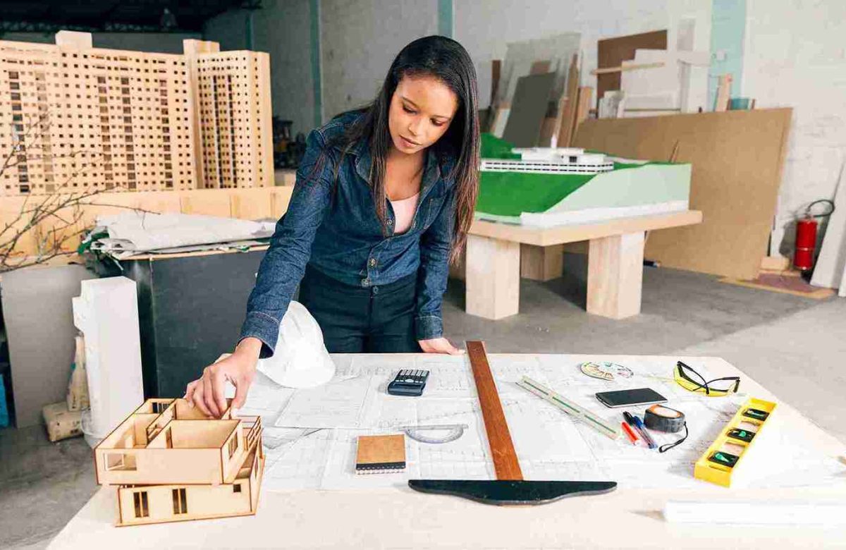 african american woman with model house table near safety helmet equipments 11zon african american woman with model house table near safety helmet equipments 11zon